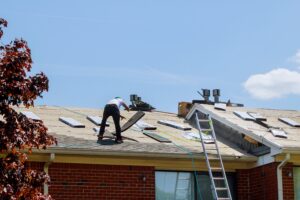 men on roof repairing home